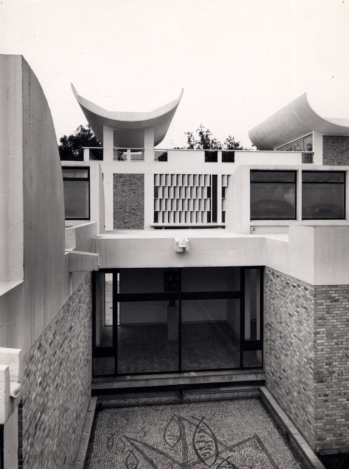 Concrete building with stone and multiple shapes.