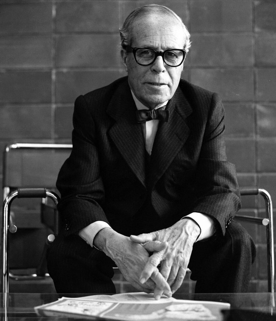 A man sits in a chair leaning forward.