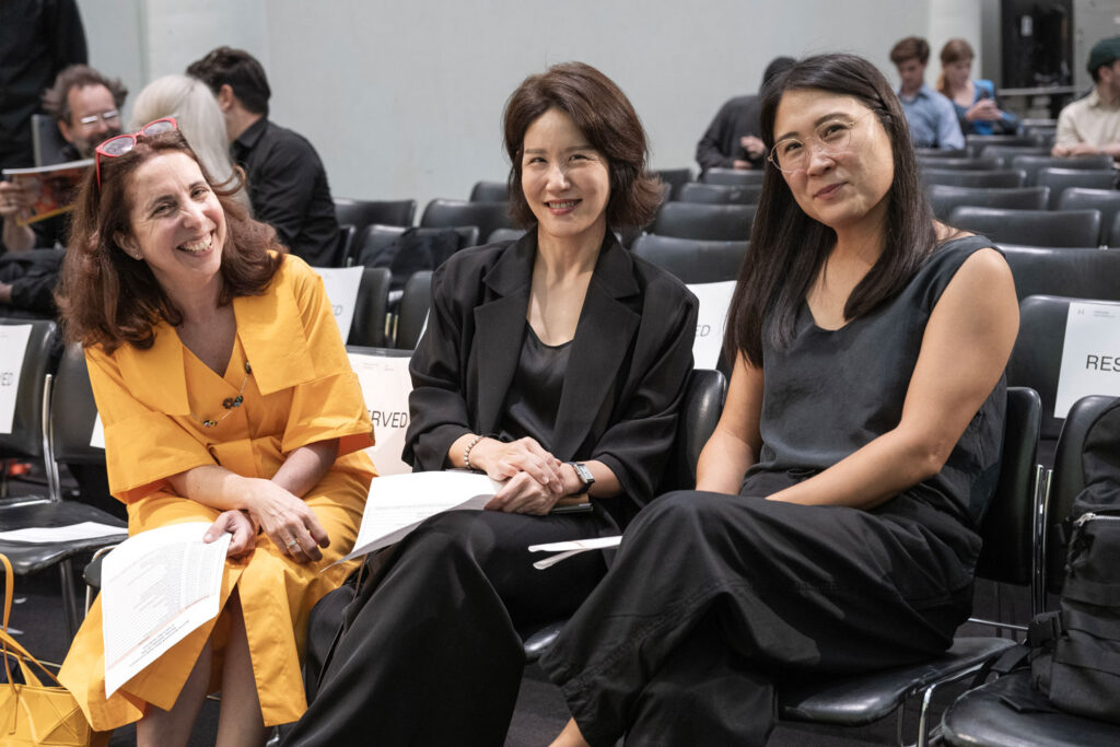 Three women sit in Piper auditorium at the GSD.