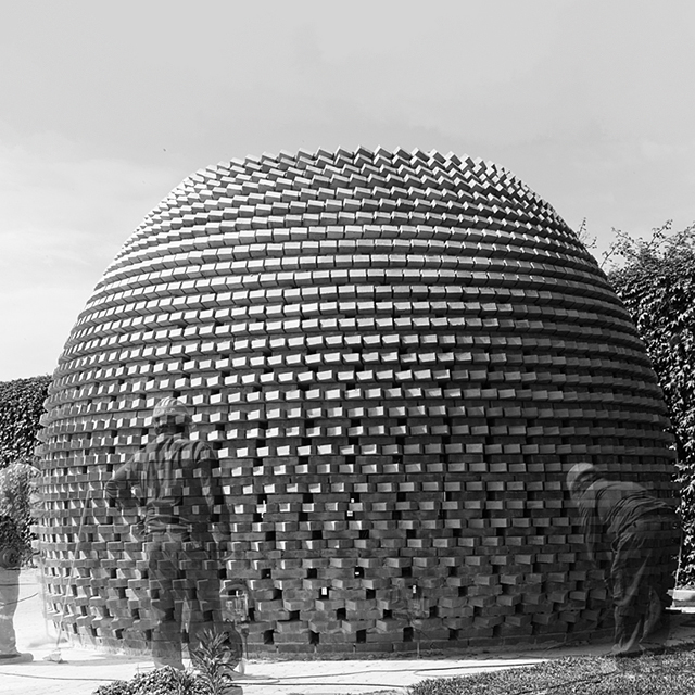 Black and white image of dome with people standing around it.