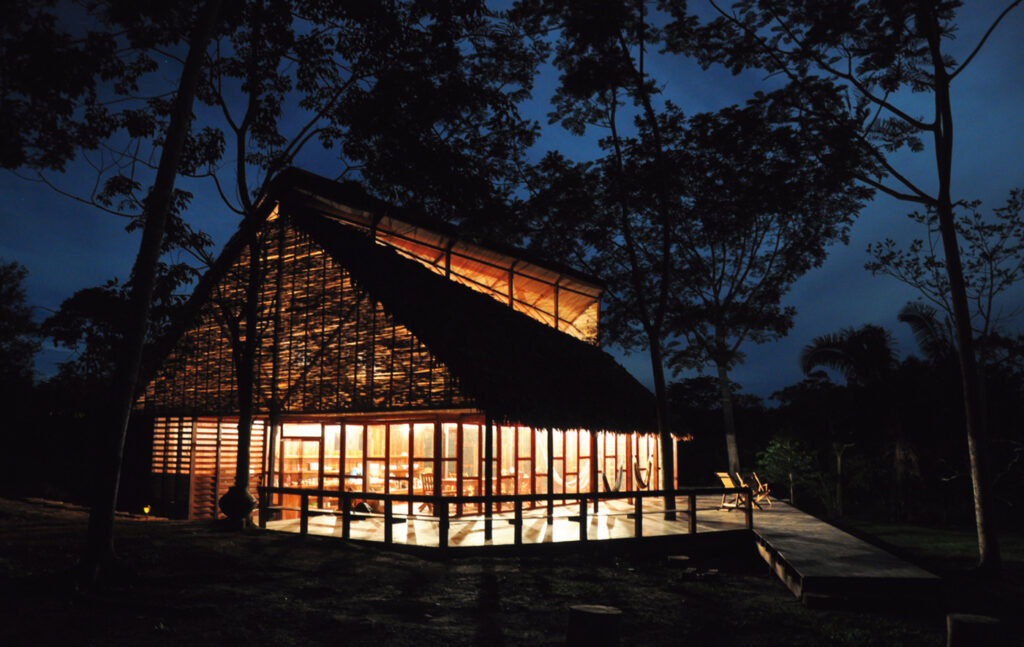 Traditional Peruvian structure at night, lit from the interior.
