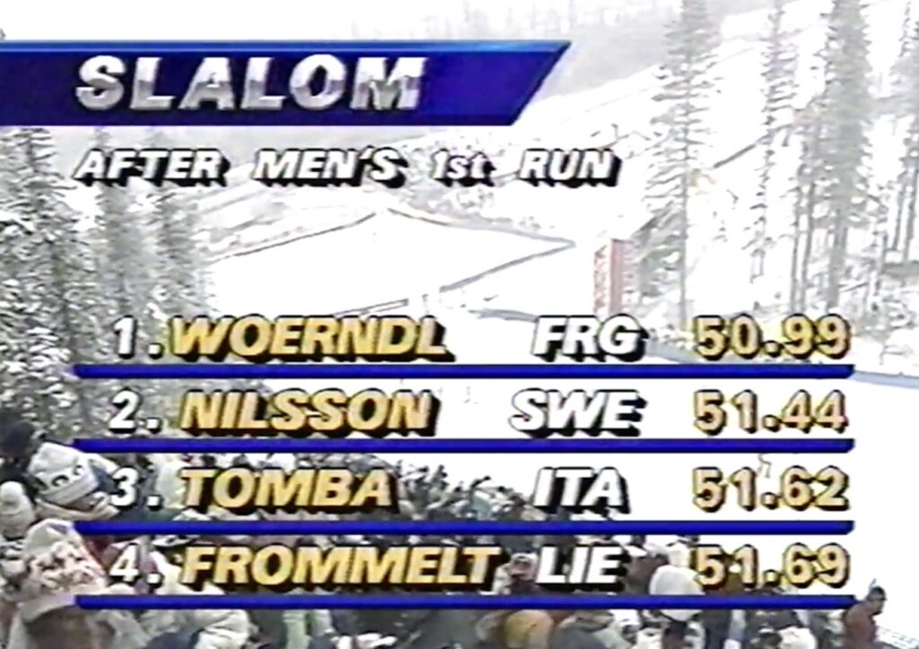 Still image of a TV screen with scores listed for slalom skiing, snow in background.