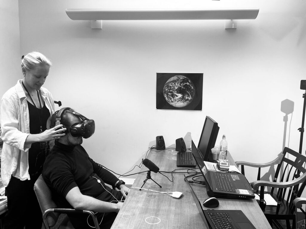 A researcher positions a virtual reality goggle set onto a human test subject.